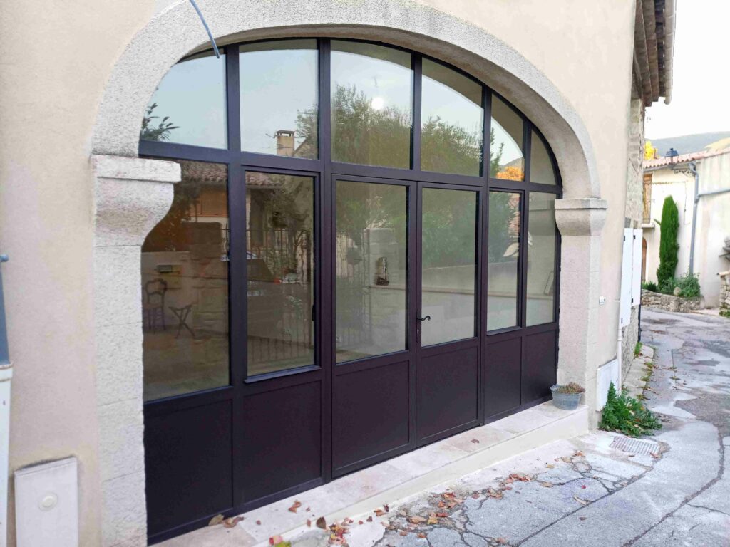 Verrière en arche 4,50 × 3,50 m, équipée de deux ouvrants de passage et de deux ouvrants d'aération. Finition thermolaquée et vitrage anti-effraction.