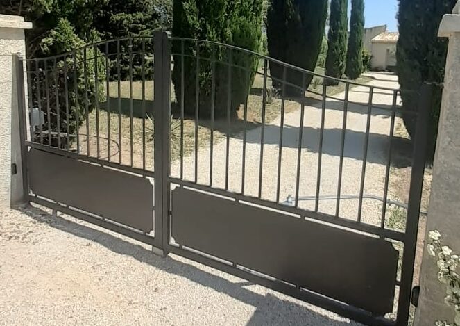 Portail barreaudé avec soubassement plein, limitant le passage des animaux domestiques et sauvages.