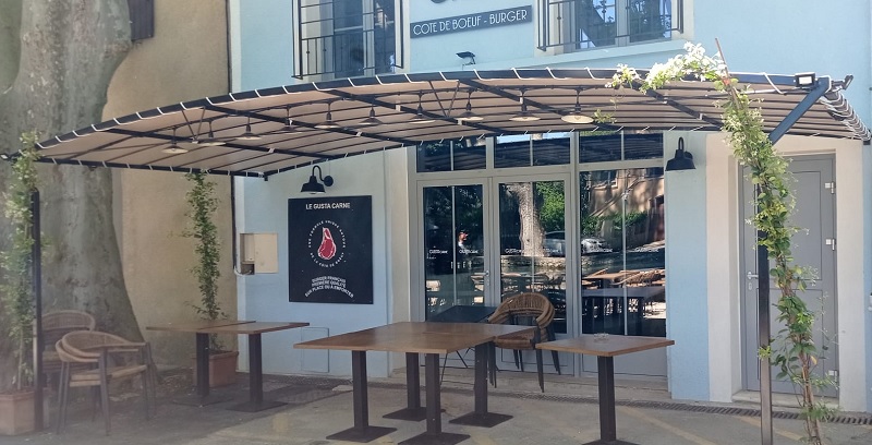 Tonnelle en tuiles pour terrasse de restaurant, à arc discret, avec couverture en toile PVC.